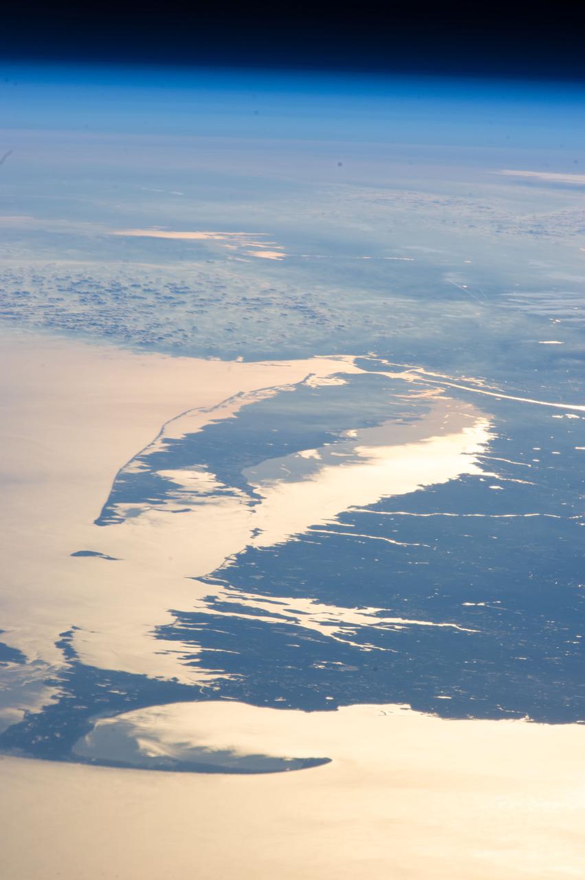Blick auf Küsten- und Meeresflächen unter der dünnen Atmosphäre der Erde